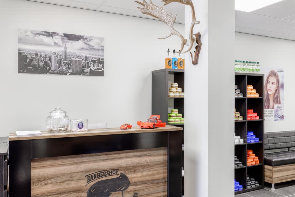 De balie met een houten front en daarachter kasten met producten