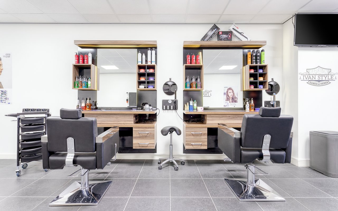 Twee kapplaatsen met spiegels, houten kasten en zwarte stoelen